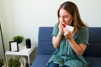 Frau mit Nasenbluten auf dem Sofa