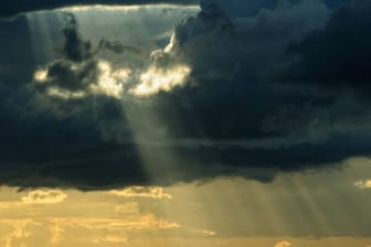 Sonne bricht durch dichte Wolken (Symbolbild): Am Sonntag soll stellenweise die Sonne herauskommen.