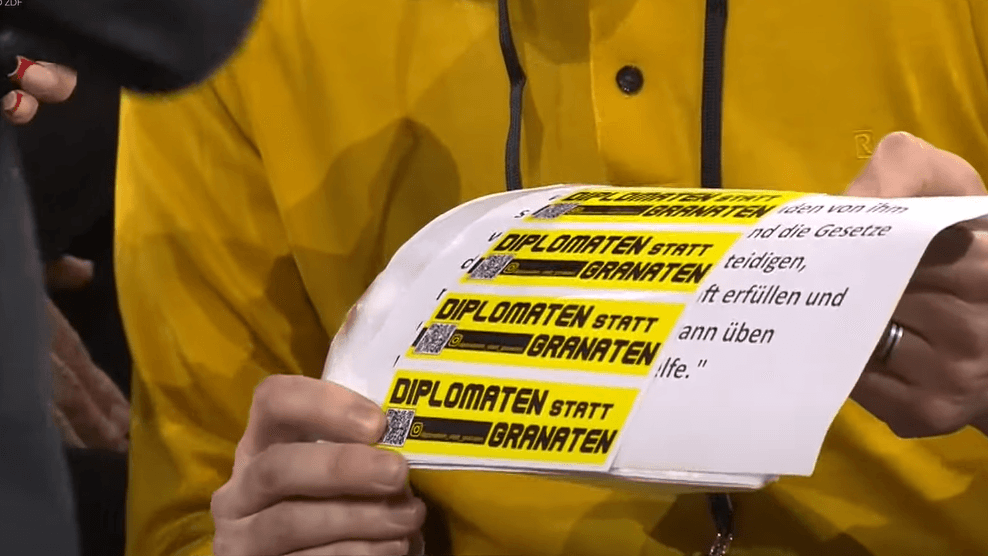 Ein "Geschenk" an den Kanzler beim Bürgerdialog in Dresden: Olaf Scholz greift den Slogan auf und reicht ihn gleich weiter.