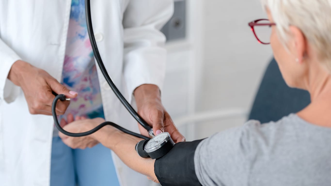 Eine Ärztin misst den Blutdruck einer Patientin.