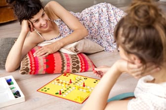 Zwei Frauen spielen "Mensch ärgere Dich nicht" (Symbolfoto): Das Brettspiel kam bereits im Jahr 1910 auf den Markt, mittlerweile sind tausende neue dazu gekommen.