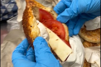 Ein Zollbeamter schaut sich das Baguette genauer an: Neben Käse und Tomaten war dieses auch mit dem Schmuckstück belegt.