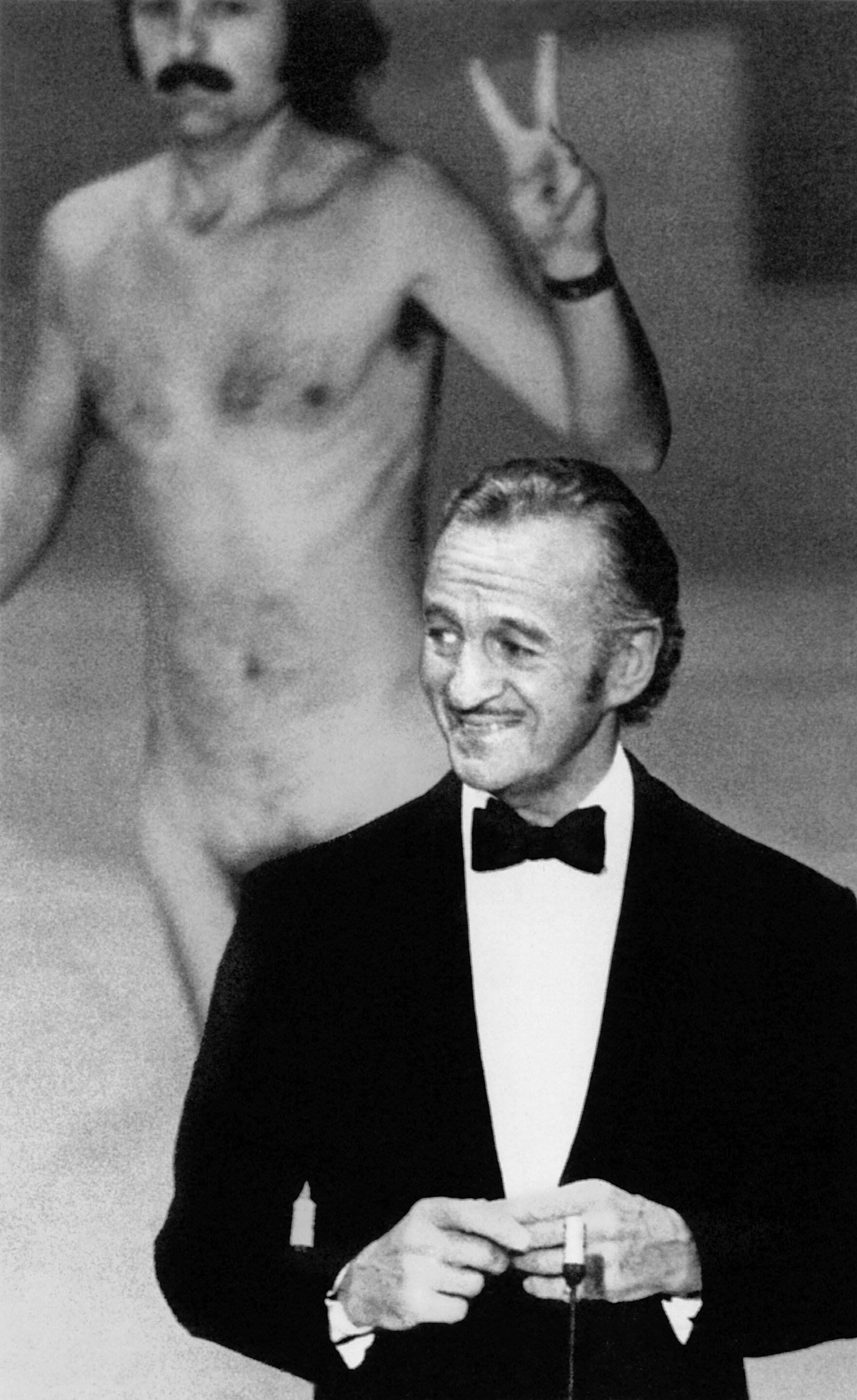 David Niven 1974 bei den Oscars – und hinter ihm im Vorbeirennen Robert Opel.