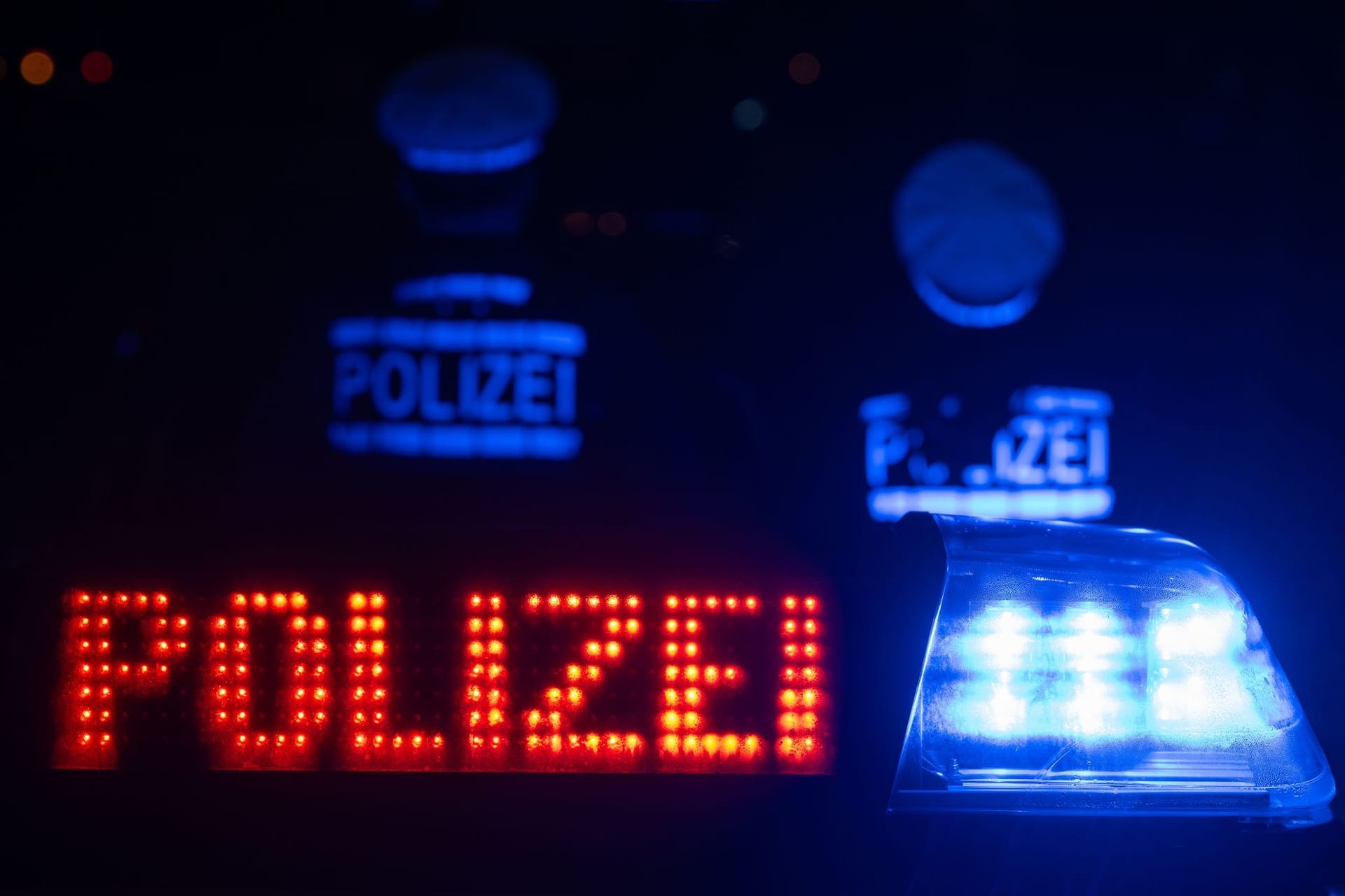 Zwei Polizisten stehen vor einem Polizeifahrzeug (Symbolfoto): Zu dem oder den Täter war zunächst nichts bekannt.