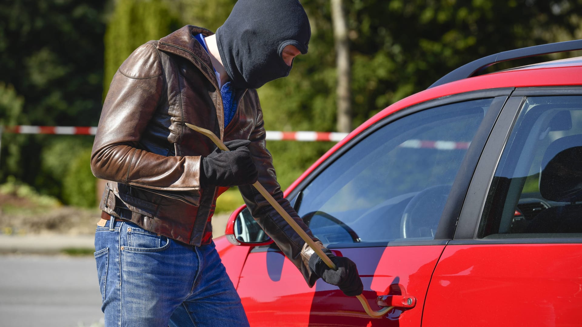 Ein Mann versucht ein Auto aufzubrechen (Symbolfoto): In Bremen passierte einem Autoknacker ein interessantes Missgeschick. Ein Mann versucht ein Auto aufzubrechen (Symbolfoto): In Bremen passierte einem Autoknacker ein interessantes Missgeschick.