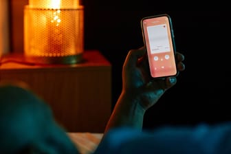 Man using dating app in bed at night