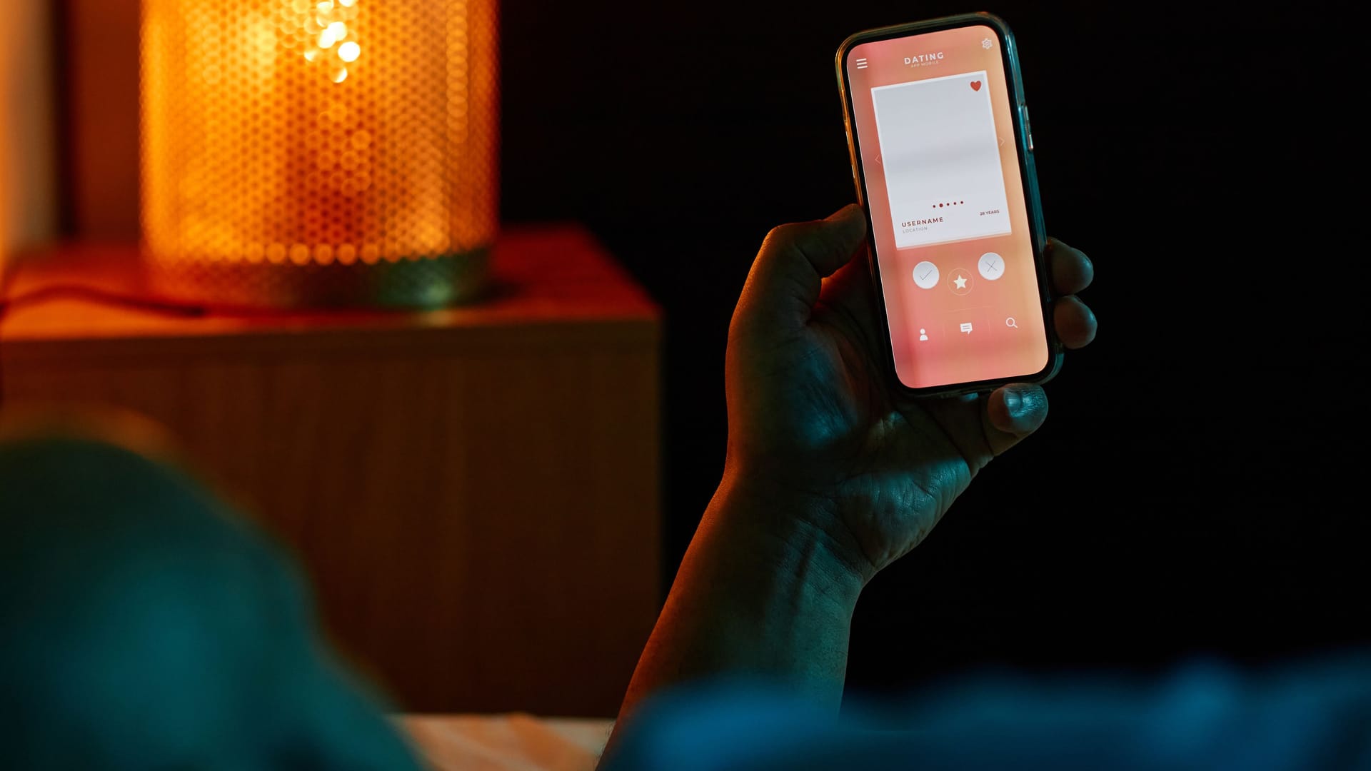 Man using dating app in bed at night