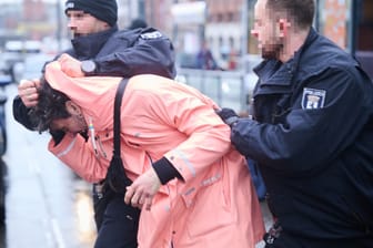 Berliner Polizisten halten einen Unterstützer der "Letzten Generation" an der Warschauer Brücke fest