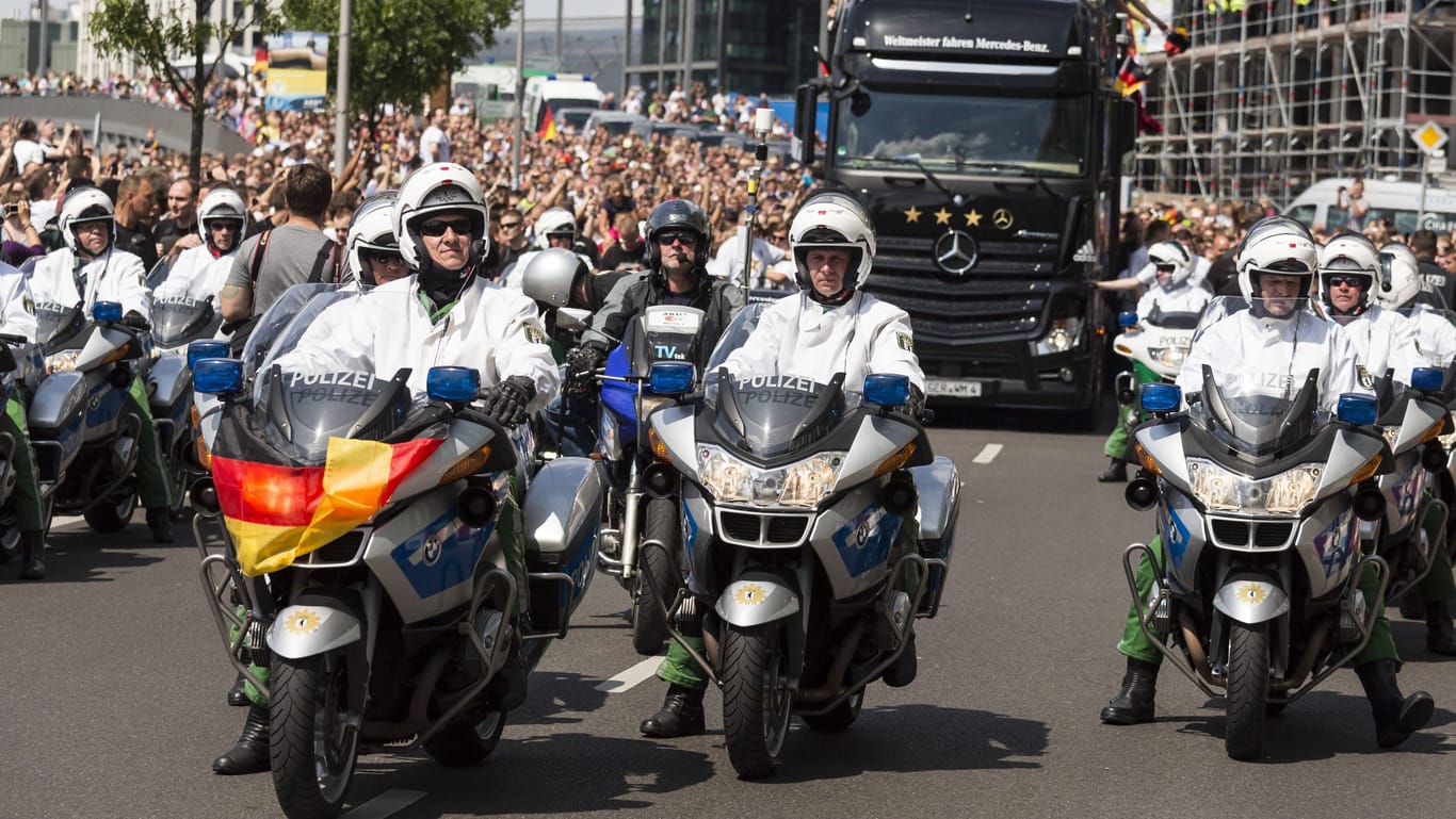 Siegesfeier nach dem WM-Titel 2014 (Archivbild): Hier fährt ein Polizeibeamter mit einer Flagge am Motorrad vor dem Bus der DFB-Stars.