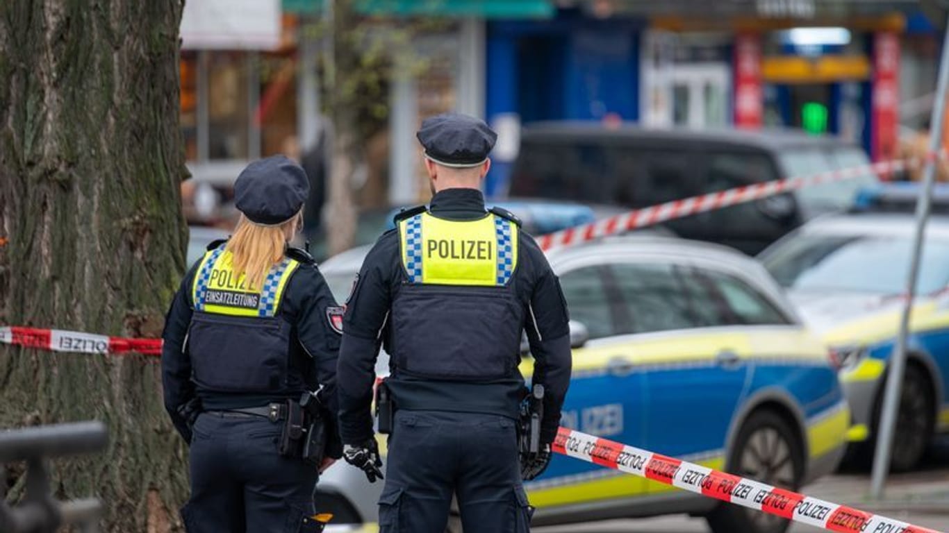 Polizisten stehen im Bahnhofsviertel St. Georg hinter einem Absperrband. Auf dem Gehweg am Steindamm Ecke Adenauerallee wurde am frühen Morgen ein Mann gefunden, der angeschossen und lebensgefährlich verletzt worden war.