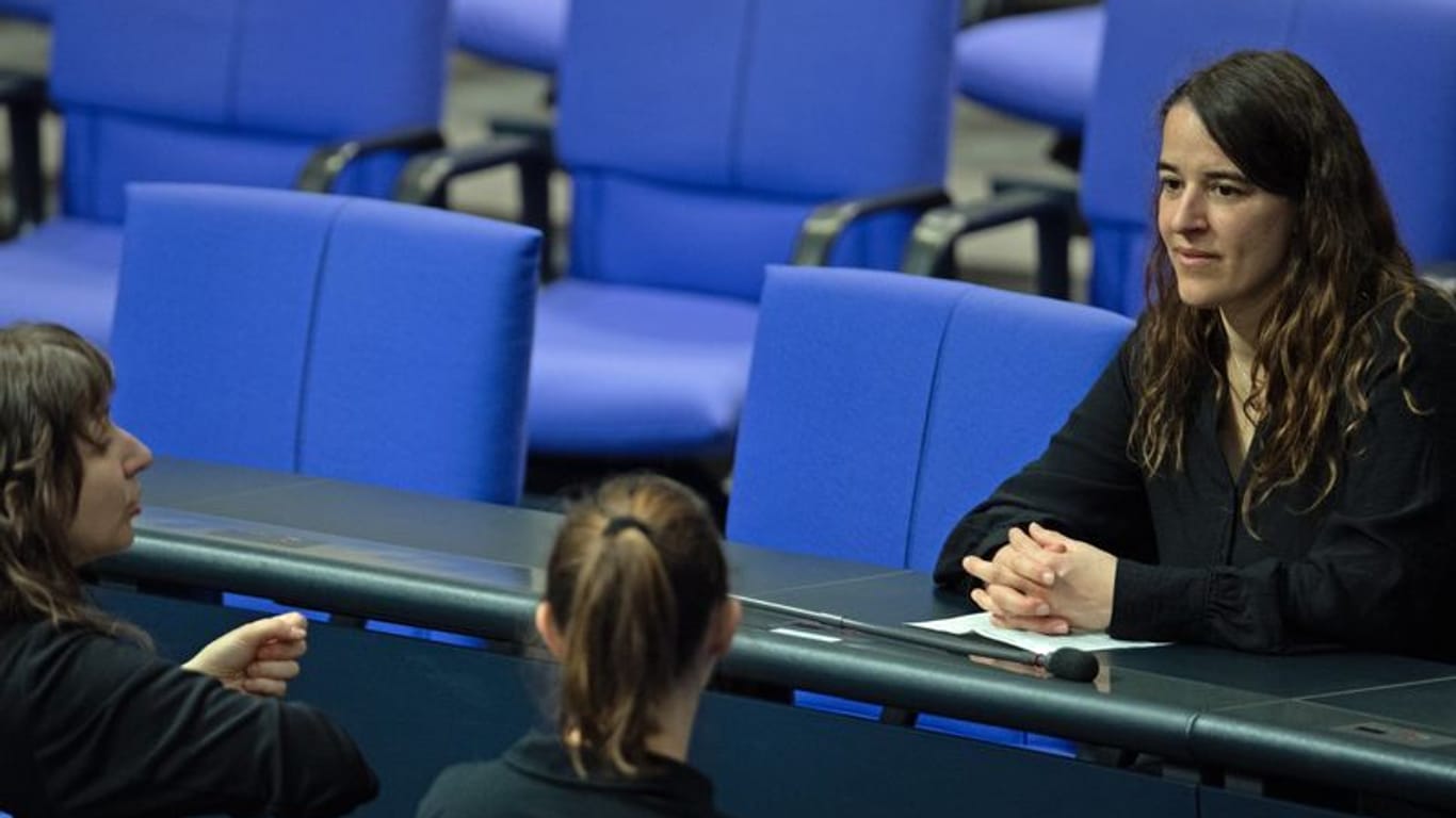 Heike Heubach (R, SPD): Die erste gehörlose Bundestagsabgeordnete erhält von ihren Dolmetscherinnen eine Übersetzung.