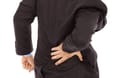 Eine Person fasst sich an den Rücken (Symbolbild): Rücken-, Kopf- und Gelenkschmerzen gehören zu den häufigsten Arten chronischer Schmerzen.