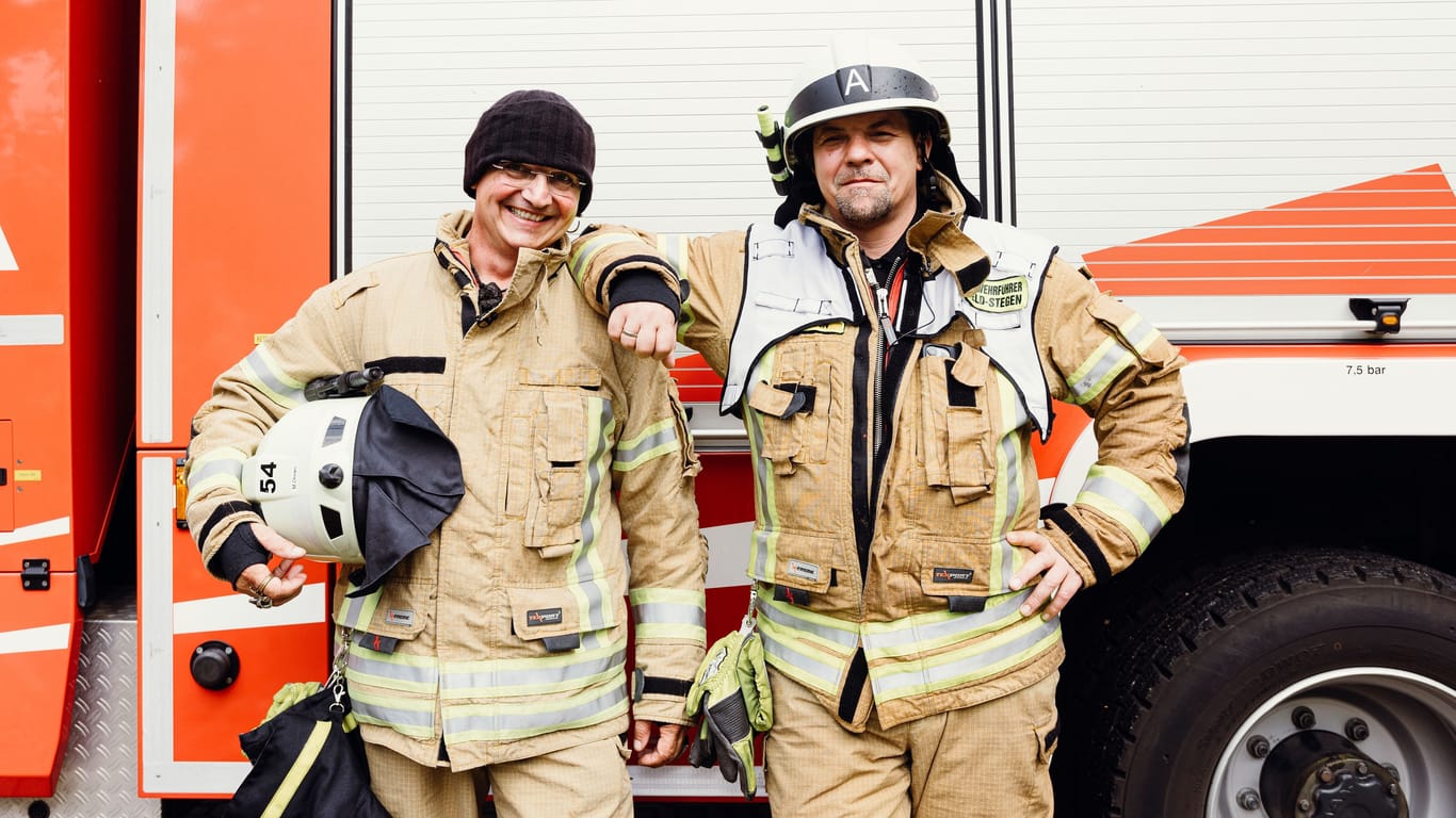 Stefan Wiesner (l.) und Tim Mälzer vor einem Feuerwehrwagen: Die beiden TV-Koche absolvieren "feuerwehrtypische" Aufgaben.