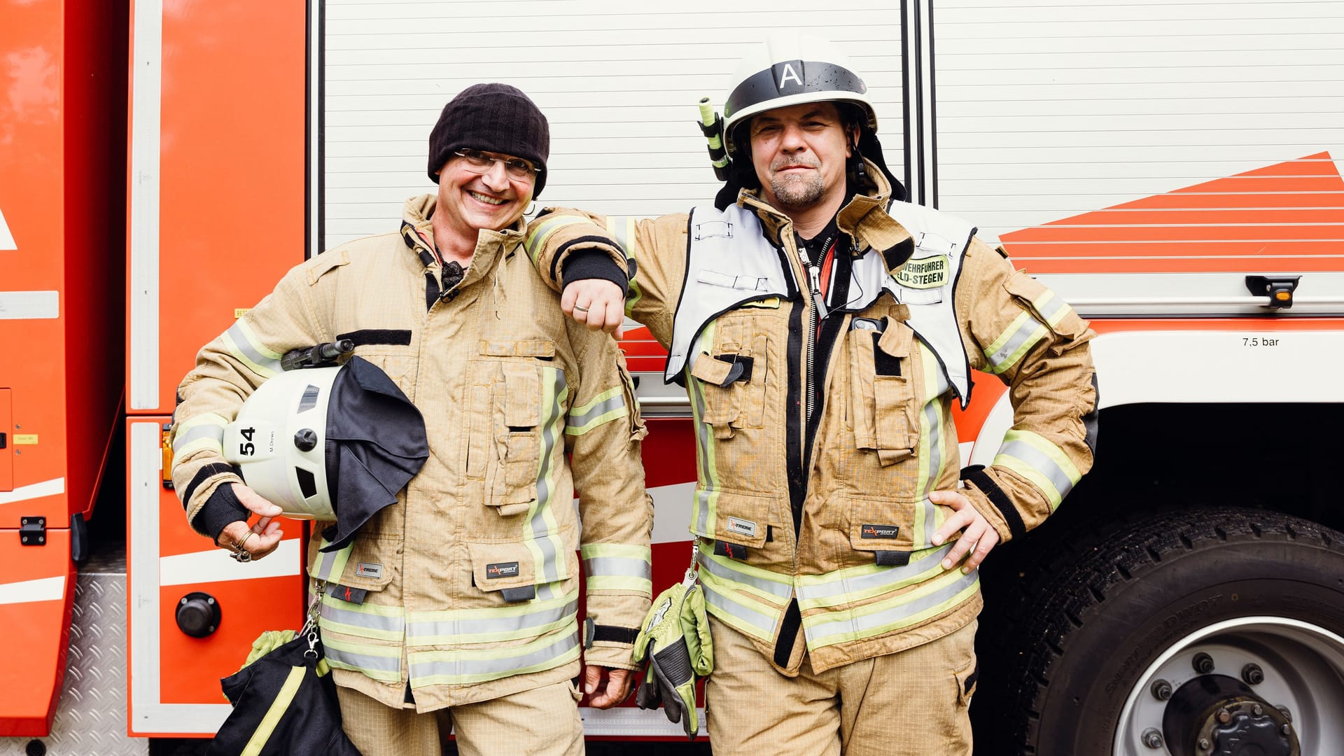 Stefan Wiesner (l.) und Tim Mälzer vor einem Feuerwehrwagen: Die beiden TV-Koche absolvieren "feuerwehrtypische" Aufgaben.