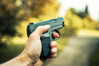 Ein Mann hält eine Waffe in der Hand (Symbolbild): Die Polizei hat ein Ermittlungsverfahren wegen eines Verstoßes gegen das Waffengesetz eingeleitet.