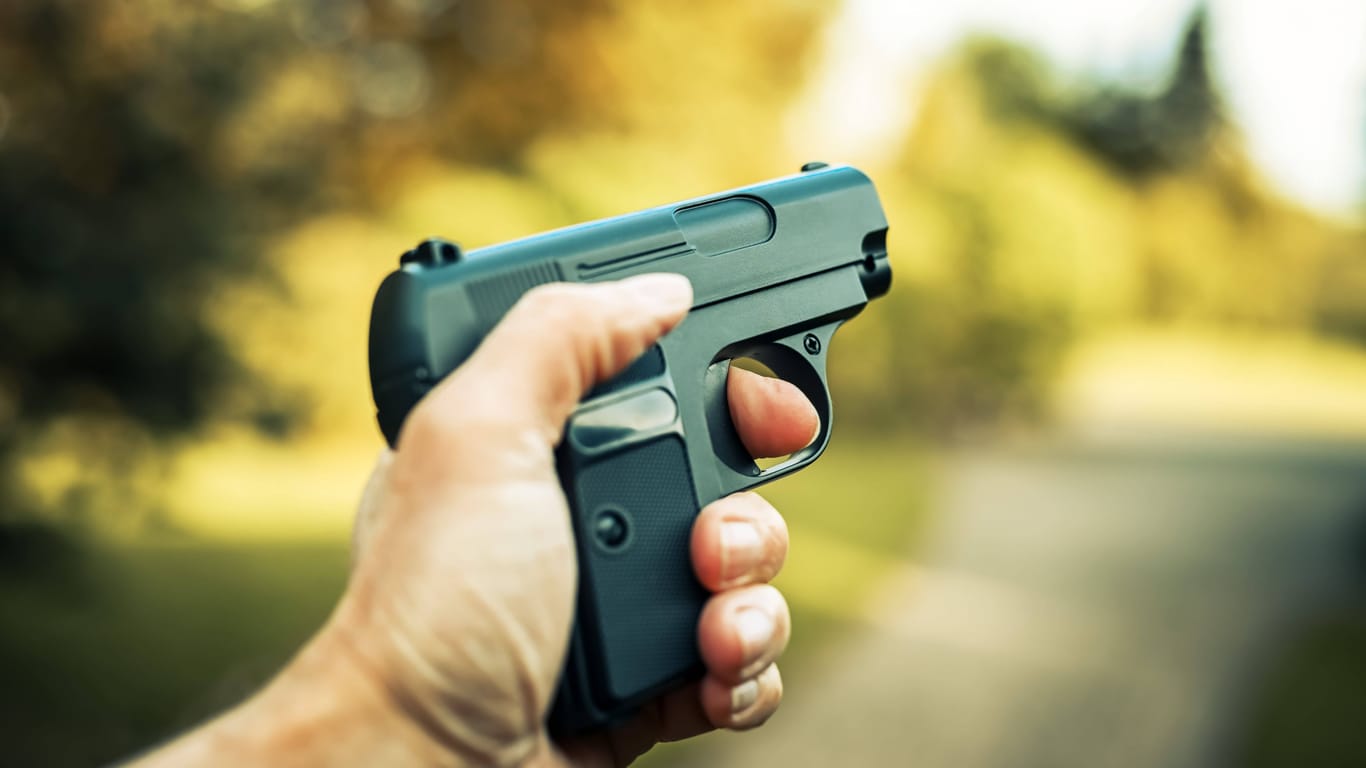 Ein Mann hält eine Waffe in der Hand (Symbolbild): Die Polizei hat ein Ermittlungsverfahren wegen eines Verstoßes gegen das Waffengesetz eingeleitet.