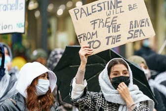 Eine Frau hält ein Schild mit der Parole "From the river to the see" hoch (Symbolbild): Bei einer pro-Palästina Demo kam es zu einer Hassrede.