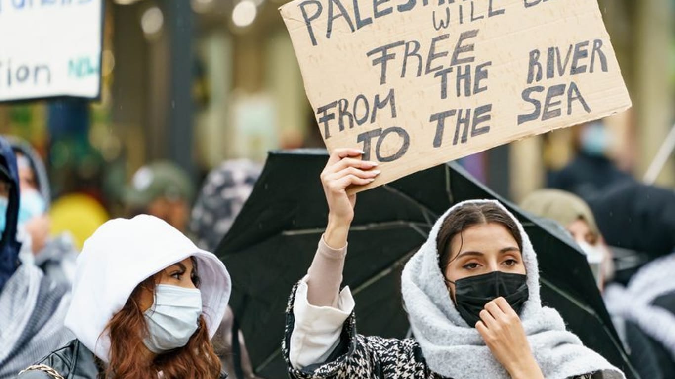 Eine Frau hält ein Schild mit der Parole "From the river to the see" hoch (Symbolbild): Bei einer pro-Palästina Demo kam es zu einer Hassrede.