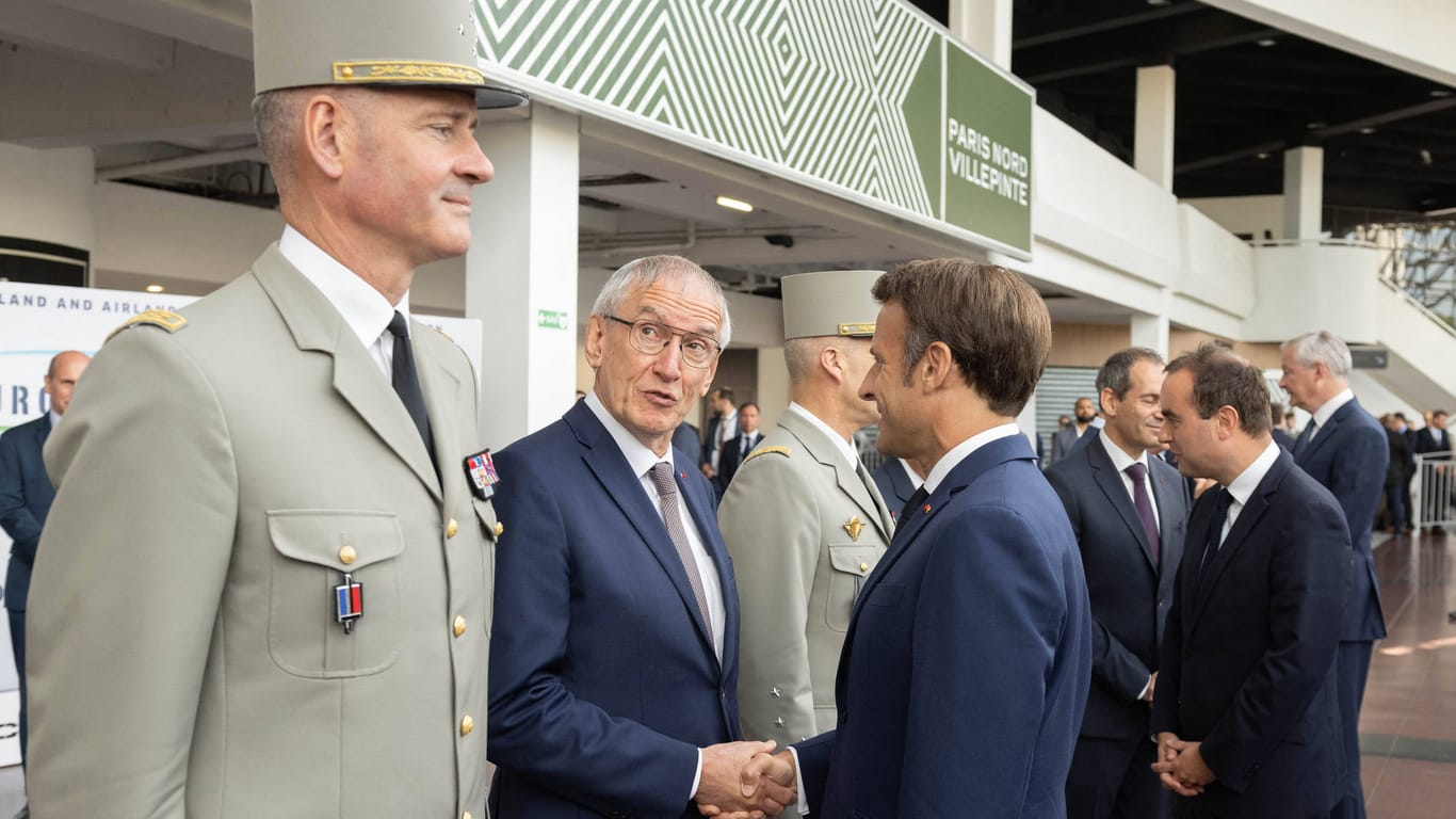 General Pierre Schill, Waffenlogistiker Joel Barre und Emmanuel Macron (v.l.) bei einer Ausstellung. Schill warnt Russland, dass Frankreich für einen Konflikt vorbereitet sei.