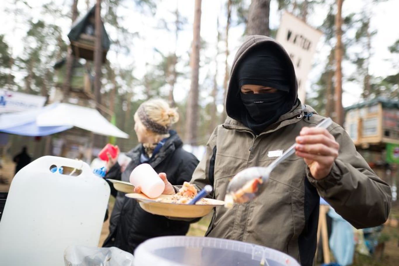 Ein Aktivist nimmt sich in einem Protestcamp nahe der Tesla-Gigafactory eine Portion Porridge.
