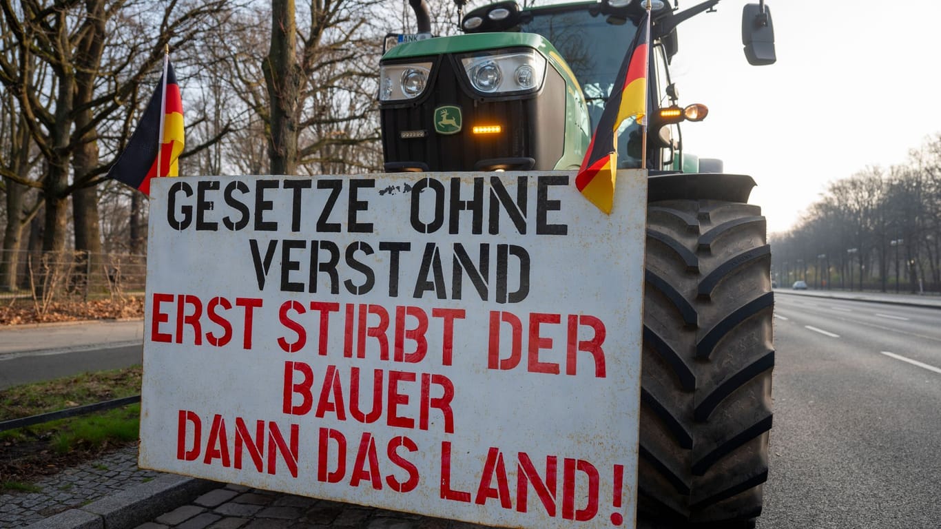 An einem Traktor hängt ein Schild mit der Aufschrift "Gesetze ohne Verstand - Erst stirbt der Bauer dann das Land!": In Berlin gehen die Bauernproteste am Freitag weiter.