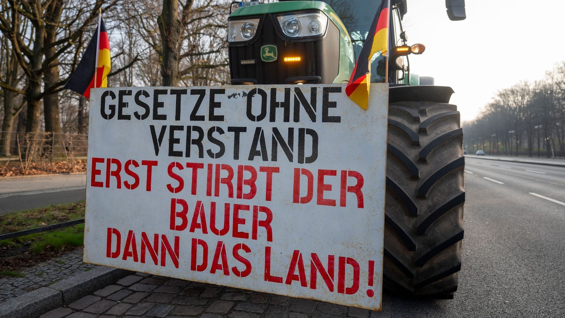 An einem Traktor hängt ein Schild mit der Aufschrift "Gesetze ohne Verstand - Erst stirbt der Bauer dann das Land!": In Berlin gehen die Bauernproteste am Freitag weiter.