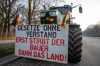 An einem Traktor hängt ein Schild mit der Aufschrift "Gesetze ohne Verstand - Erst stirbt der Bauer dann das Land!": In Berlin gehen die Bauernproteste am Freitag weiter.