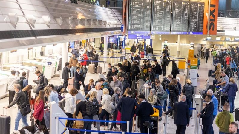 Fluggäste warten am Check-In-Schalter auf ihren Flug in den Urlaub (Symbolbild): In Köln und Düsseldorf gab es zum Ferienbeginn keine Probleme.