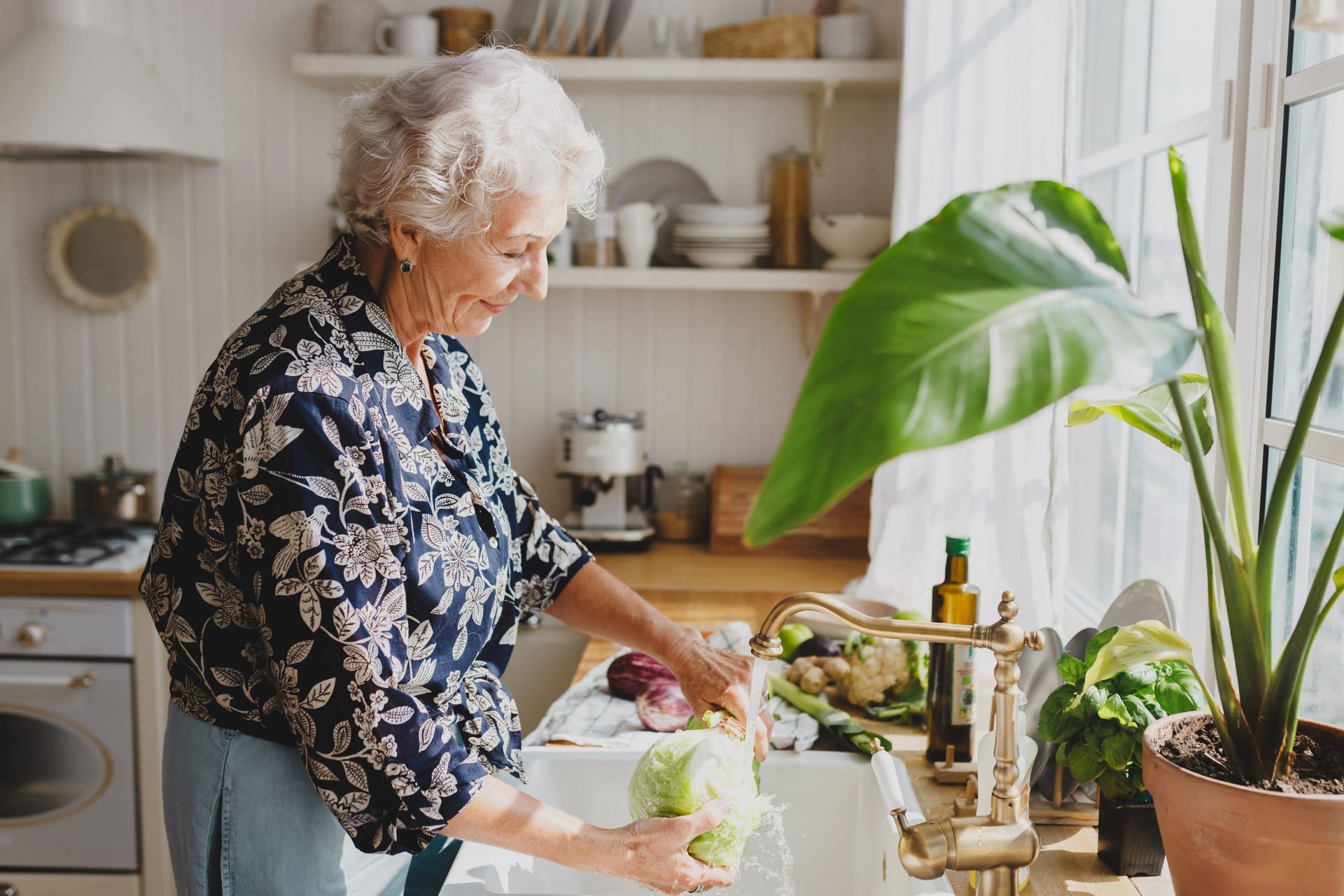 Eine Frau wäscht einen Salatkopf ab