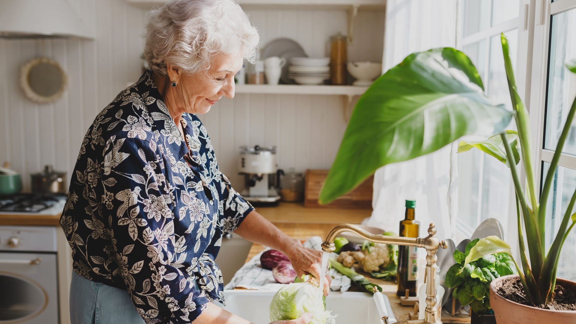 Eine Frau wäscht einen Salatkopf ab