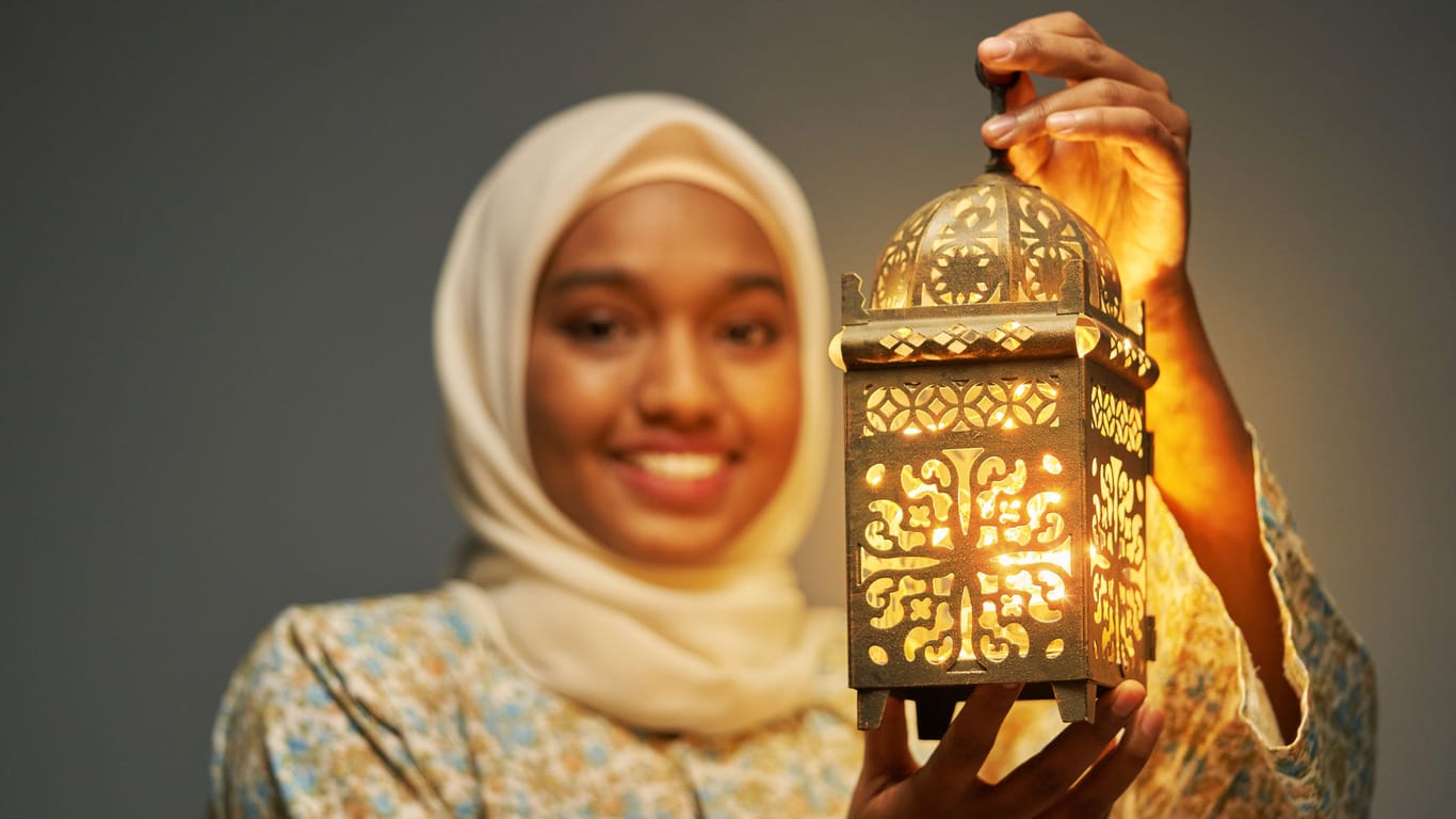 Eine junge Frau im Hijab präsentiert eine traditionelle arabische Laterne (Archivbild): Ramadan auf TikTok macht die Bräuche, aber auch die Ideen des Ramadan sichtbar.