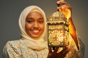 Eine junge Frau im Hijab präsentiert eine traditionelle arabische Laterne (Archivbild): Ramadan auf TikTok macht die Bräuche, aber auch die Ideen des Ramadan sichtbar.