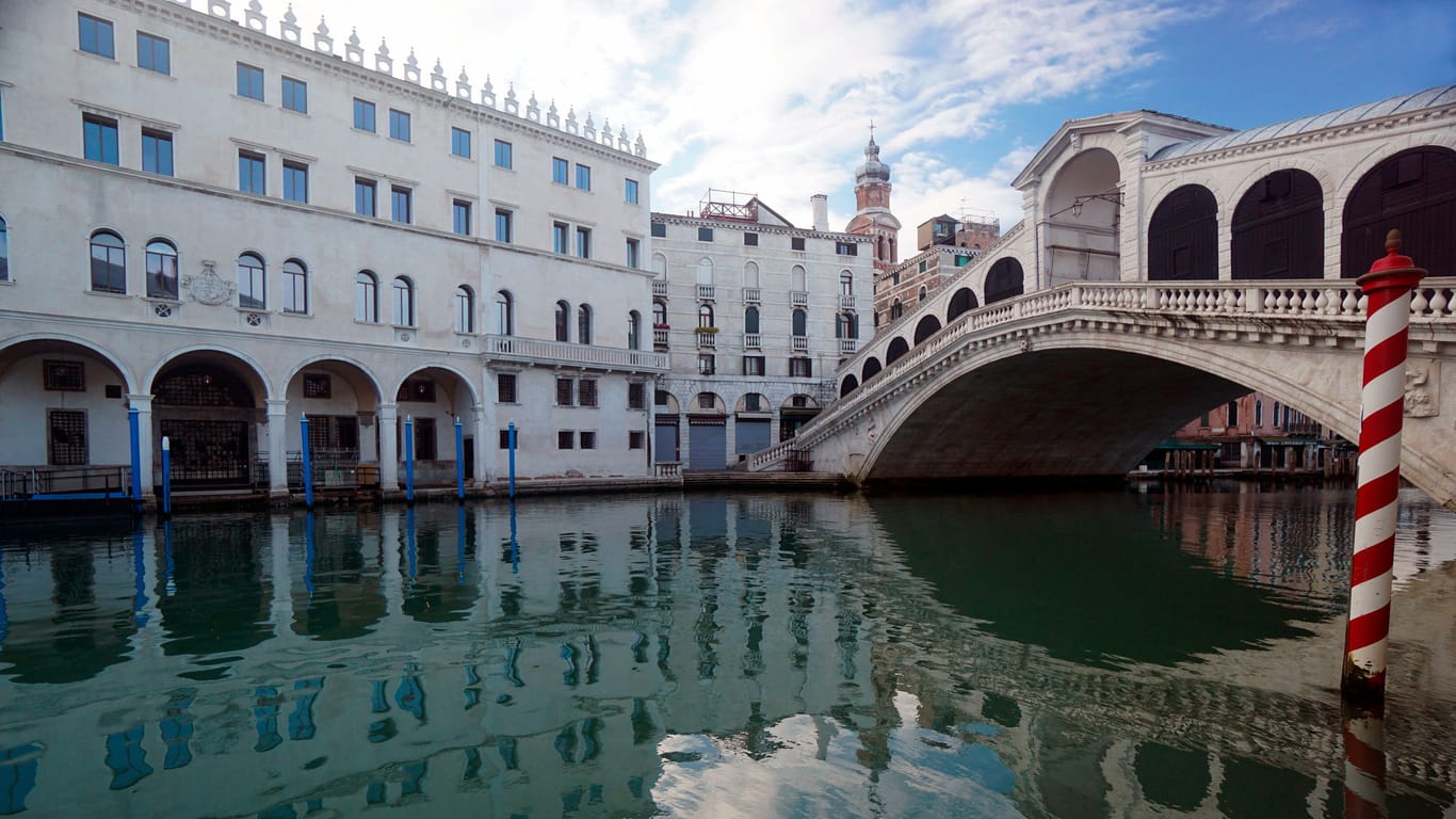 Die Rialtobrücke in Venedig spiegelt sich im Canal Grande: Wer die Stadt als Tagestourist besuchen will, muss bald an manchen Tagen Eintritt zahlen.