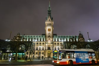 Ein Bus der Hochbahn vorm Hamburger Rathaus (Archivbild): Am 23. März gehen hier für eine Stunde die Lichter aus.