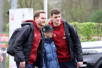 Eric Martel (re.) und Benno Schmitz am Samstag mit einem Fan vor der Abfahrt des 1. FC Köln nach Augsburg.