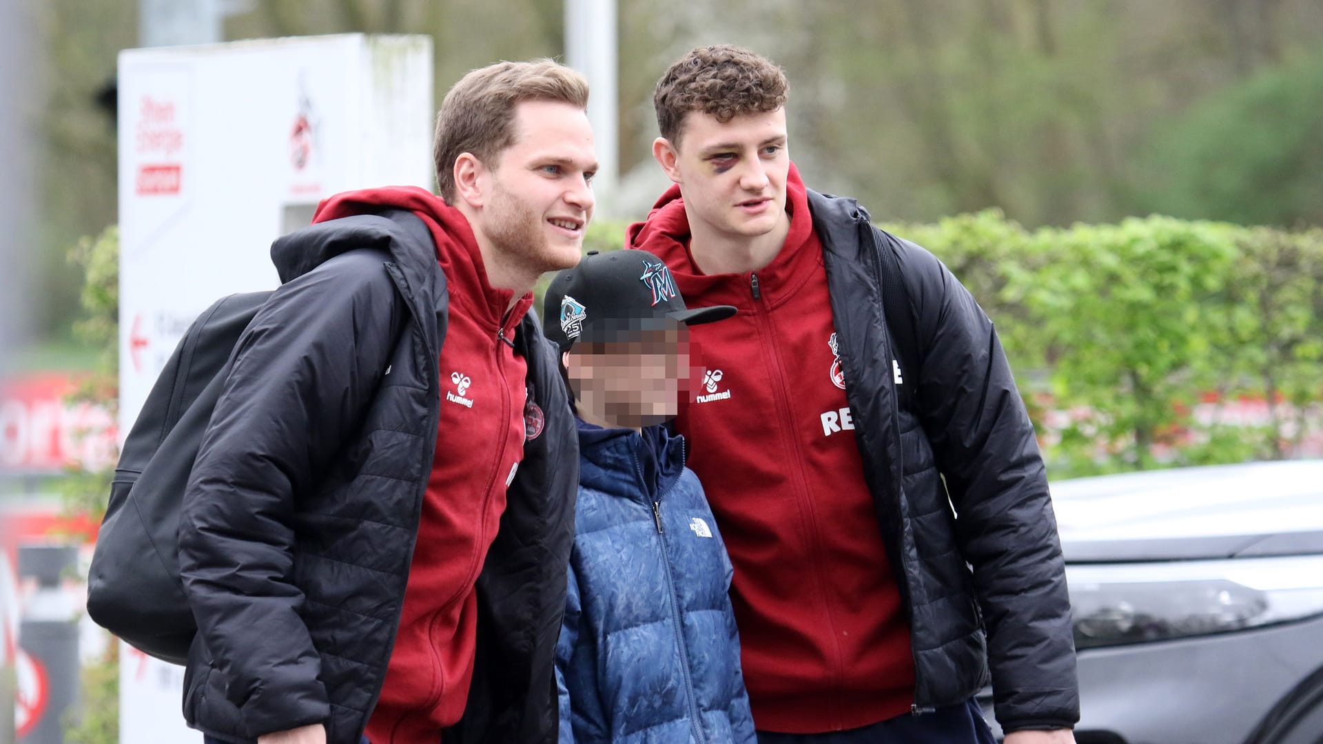 Eric Martel (re.) und Benno Schmitz am Samstag mit einem Fan vor der Abfahrt des 1. FC Köln nach Augsburg.