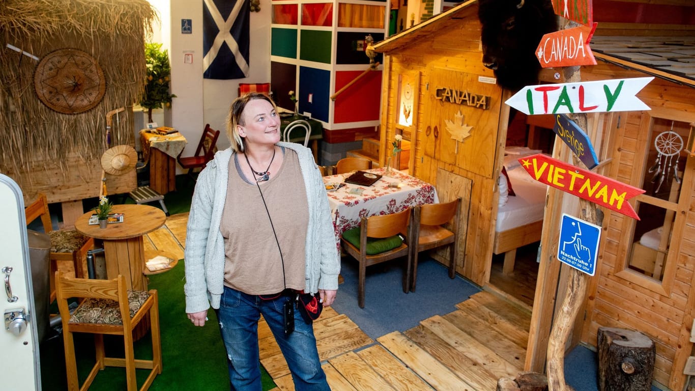 Claudia Geerken, Geschäftsführerin im Hostel-Camp "HafenTraum", steht neben einer Holzhütte, die thematisch zum Reiseziel Finnland gestaltet wurde.