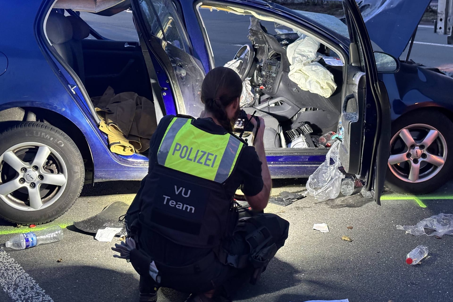 Polizistin schaut sich Unfallauto genauer an: Die A3 musste gesperrt werden.