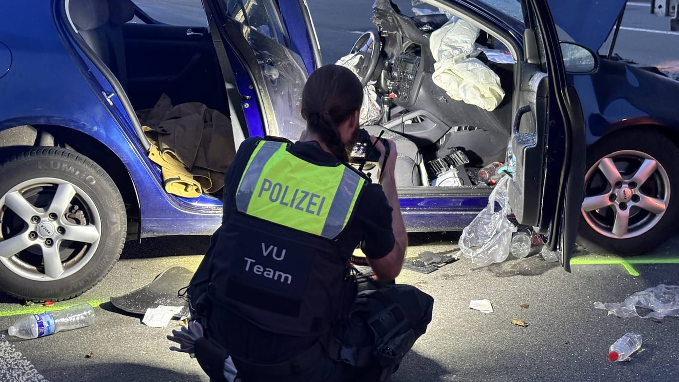 Polizistin schaut sich Unfallauto genauer an: Die A3 musste gesperrt werden.