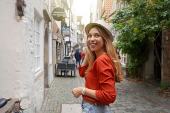 Portrait of smiling traveler woman in Schnoor neighborhood, Bremen, Germany