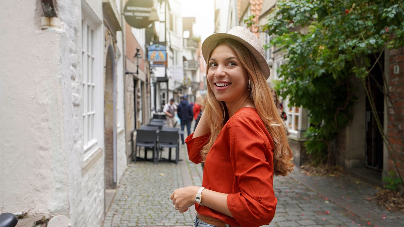 Portrait of smiling traveler woman in Schnoor neighborhood, Bremen, Germany