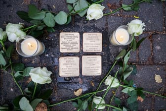 Weiße Rosen und Kerzen: Sie liegen und stehen neben den Stolpersteinen, die an das Schicksal der jüdischen Familie Frankenthal erinnern.