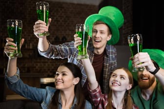 Eine Gruppe von Freunden stößt mit grünem Bier an (Symbolbild): Der St. Patrick's Day ist mittlerweile ein weltweites Ereignis.