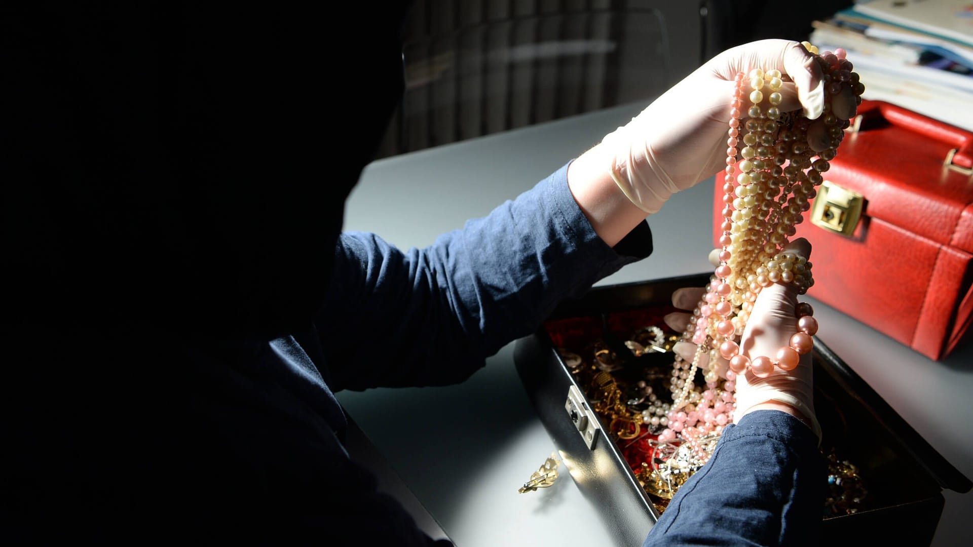 Ein Einbrecher begutachtet eine Schatulle mit Schmuck (Symbolbild): Die Täter konnten unerkannt entkommen. Ein Einbrecher begutachtet eine Schatulle mit Schmuck (Symbolbild): Die Täter konnten unerkannt entkommen.