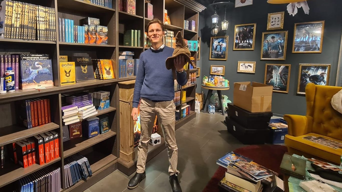 Florian Timm hält den aus Harry Potter bekannten sprechenden Hut in der Hand: Nur noch wenige Tage, dann eröffnet der neue Pop-Up-Store in München.