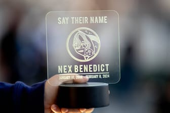 Trauer in den USA: Auf einer Demonstration im Gedenken an Nex Benedict in Nex' Heimatstadt Owasso hält eine Frau eine Erinnerungsplakette.
