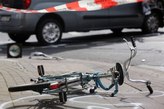 Ein Fahrrad liegt nach einem Verkehrsunfall auf der Straße (Symbolbild): In Sürth ist eine Radfahrerin angefahren worden.Ein Fahrrad liegt nach einem Verkehrsunfall auf der Straße (Symbolbild): In Sürth ist eine Radfahrerin angefahren worden.