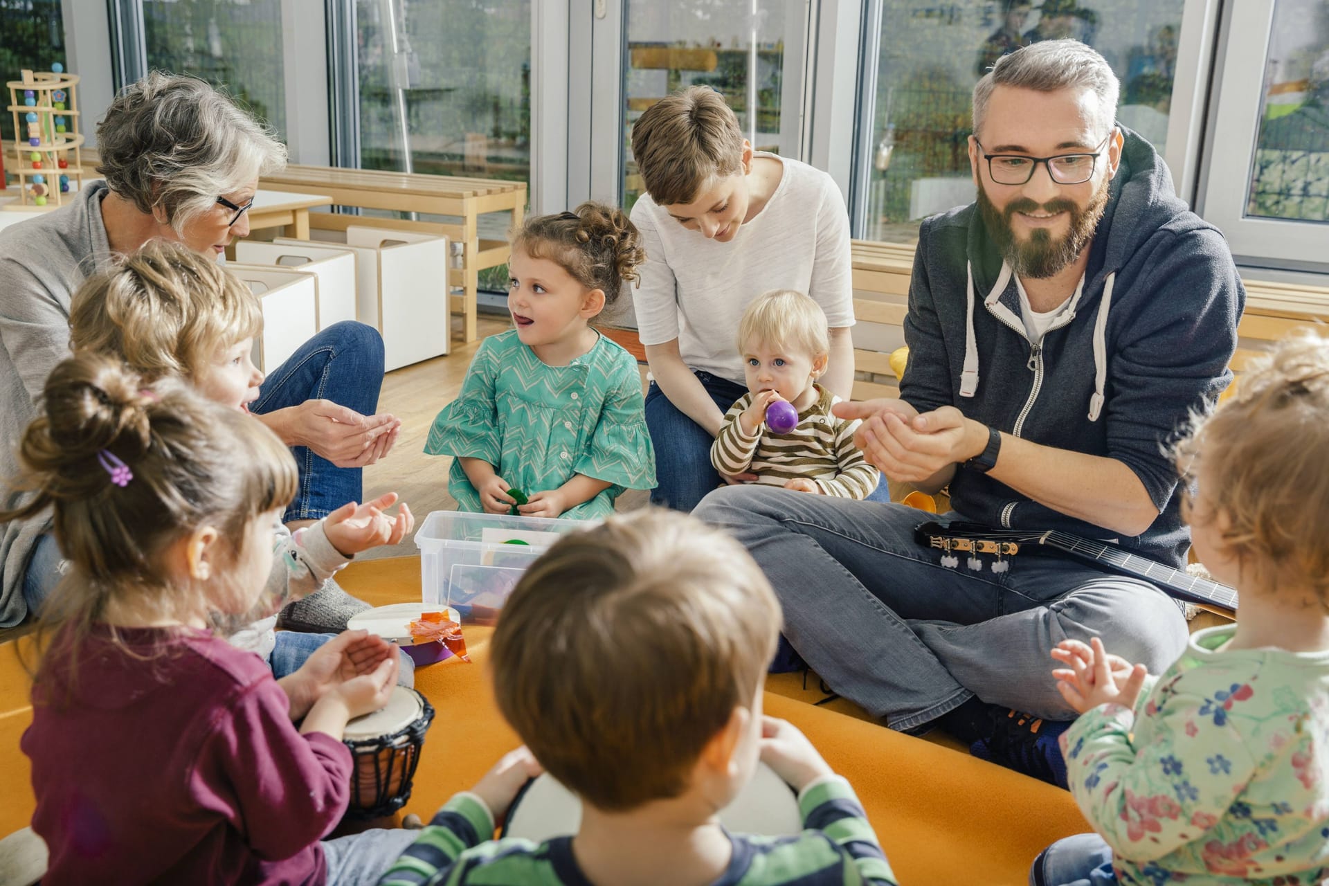 Kinder spielen mit ihren Erziehern (Symbolbild): Bis zu 430 Euro müssen Eltern in Bremen für einen Kitaplatz zahlen.