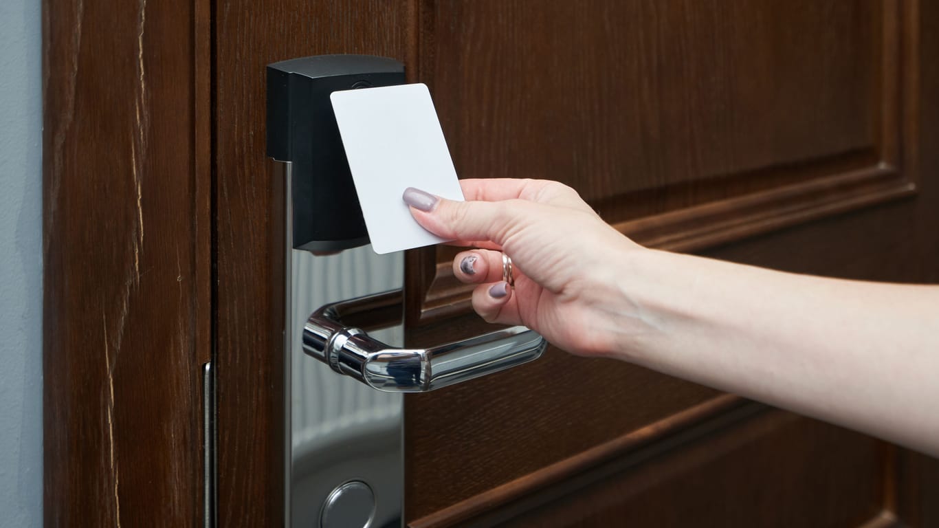 Woman opens the door in the hotel using a key card
