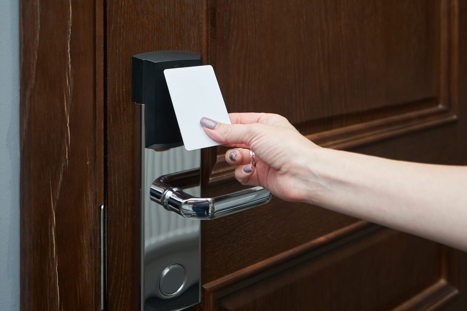 Woman opens the door in the hotel using a key card